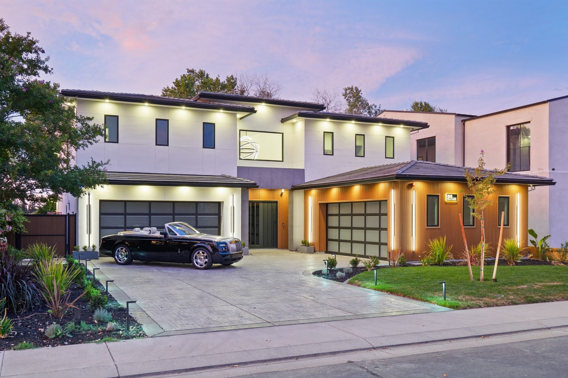 Front of 868 River Crest Drive at twilight, with warm wood accents and lit garages