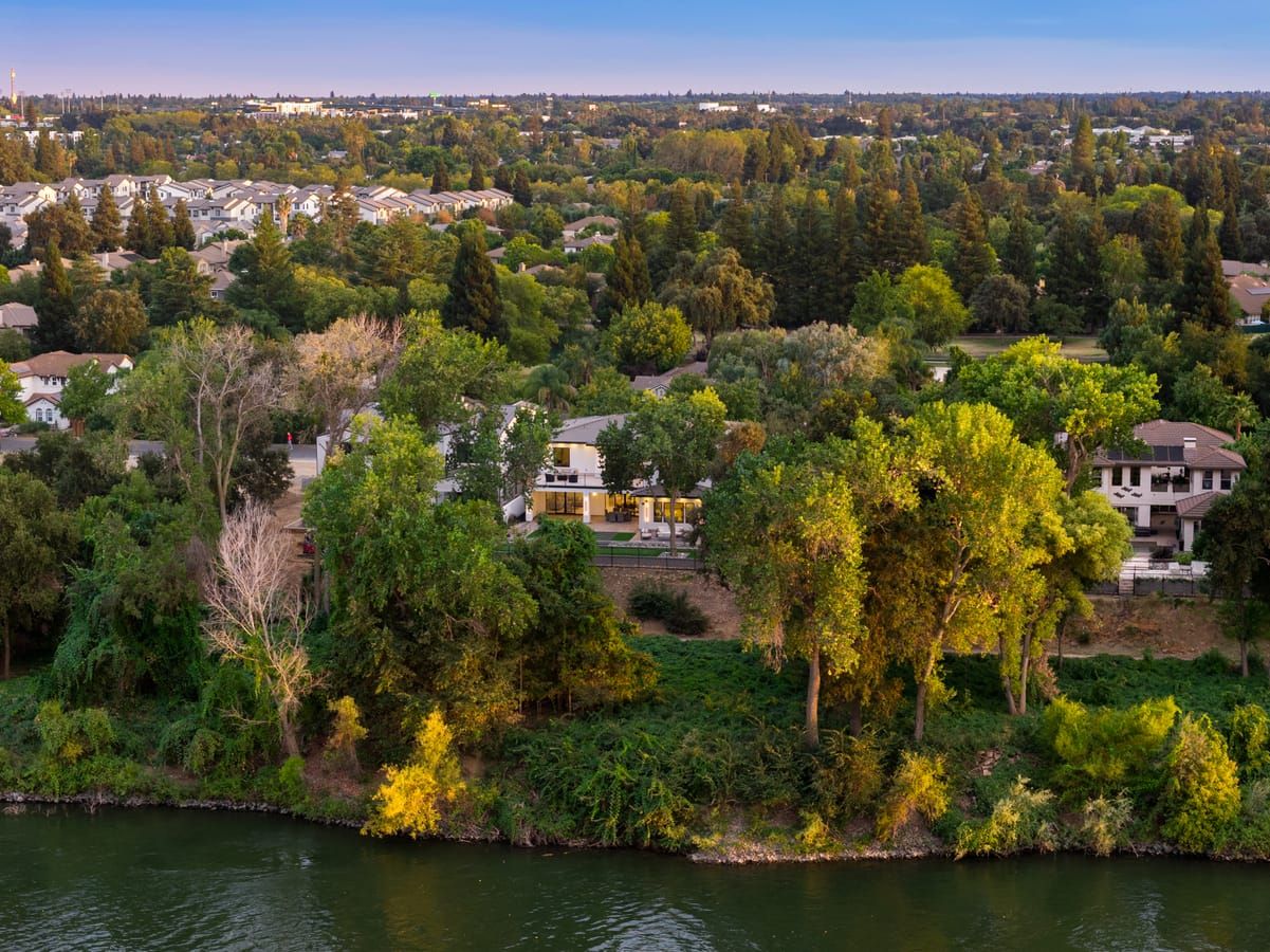 Aerial view of the home among mature trees above the Sacramento River